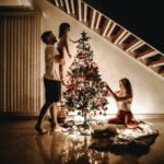 a group of people standing around a christmas tree